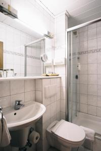 a bathroom with a sink and a toilet and a shower at Akzent Hotel Körner Hof in Dortmund