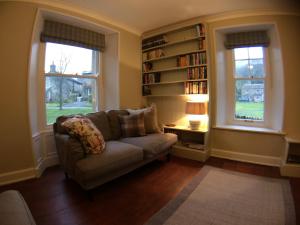 a living room with a couch and a book shelf at Green Cottage, on Langcliffe village green in Settle