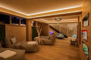 a living room with couches and chairs and a staircase at Hotel Garni Berghof in Pertisau