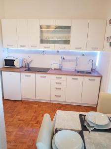 cocina con armarios blancos y mesa en Apartment Anna 2021 en Poreč