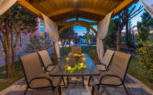 una mesa y sillas bajo un cenador en Villa Garden Star en Zakynthos