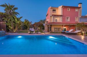 a villa with a swimming pool in front of a house at Villa Garden Star in Zakynthos Town