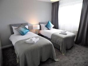 um quarto de hotel com duas camas com toalhas em Black Cart House em Johnstone