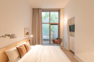 Schlafzimmer mit einem Bett und einem Fenster in der Unterkunft Great in Gent