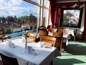 a restaurant with tables and chairs and a large window at Glashütten Hotel in Glashütten