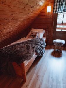 a bed in a log cabin with a pillow on it at Domki u Basi in Kudowa-Zdrój