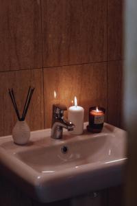 a bathroom sink with two candles on top of it at Domki u Basi in Kudowa-Zdrój