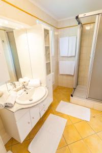 a bathroom with a sink and a shower at Ferienwohnungen Kärnten Dr. Baumgartner in Faak am See +25 photos