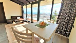 a table and chairs in a room with a large window at Sunny Days - Park Apartment in Sandanski