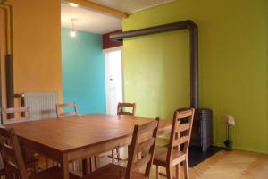 a dining room with a wooden table and chairs at La Colonie, ancienne usine horlogère in Les Pommerats