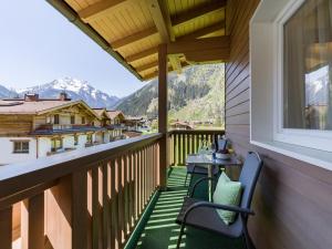 a balcony with a table and chairs and mountains at Apartments Leni in Mayrhofen