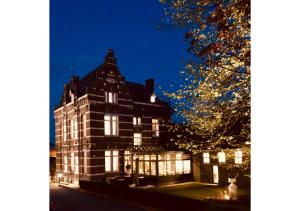 een gebouw verlicht in de nacht met lichten bij Boutique Hotel Huys van Steyns in Tongeren