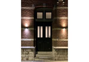 uma porta preta no lado de um edifício de tijolos em Boutique Hotel Huys van Steyns em Tongeren