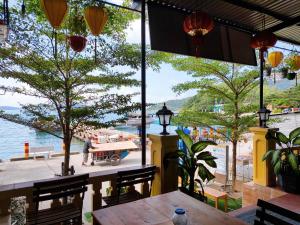 a restaurant with a table and a view of the water at Sunbay Homestay Cu Lao Cham in Tân Hiệp