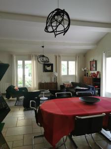 sala de estar con mesa roja y sillas en Maison au pied des ocres en Roussillon