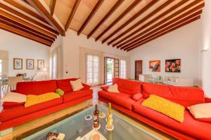 a living room with red couches and a pool at Beach Villa Margot in Port de Pollensa