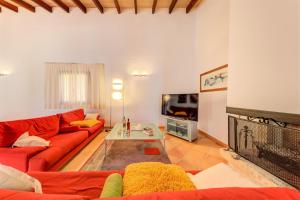 a living room with a red couch and a tv at Beach Villa Margot in Port de Pollensa