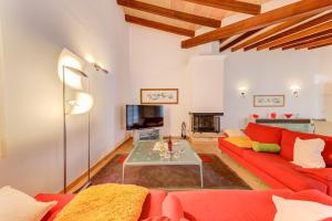 Beach Villa Margot في بورت دي بوينسا: غرفة معيشة مع أريكة حمراء وطاولة