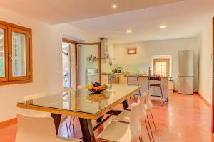 a kitchen with a dining room table and chairs at Can Cladera in Pollença