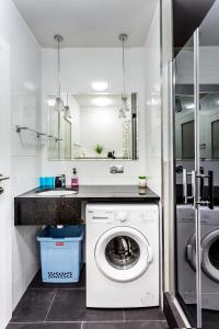 a bathroom with a washing machine and a sink at JessApart– Babka Tower Apartment in Warsaw