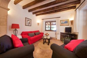 a living room with red couches and a table at Villa Mosson in Port de Pollensa