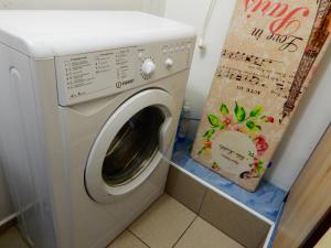 eine Waschmaschine im Bad mit einem Schild daneben in der Unterkunft Apartment-studio Royal Forest in Ramenskoje