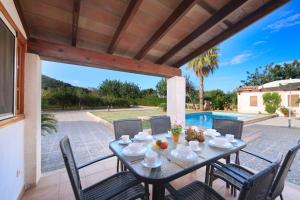 a patio with a table and chairs and a pool at Villa Fullos by Sealand Villas in Pollença