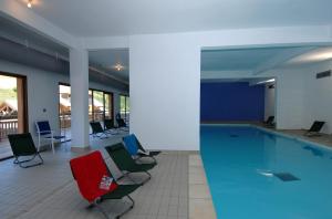 - une piscine dans un bâtiment avec des chaises et des tables dans l'établissement Résidence Odalys Pra Sainte Marie, à Vars