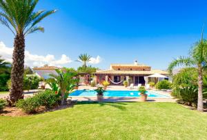 a house with a swimming pool and palm trees at Villa Aumadrava Gran by Sealand Villas in El Port