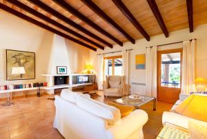 a living room with white furniture and a wooden ceiling at Villa Aumadrava Gran by Sealand Villas in El Port