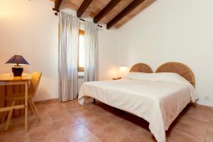 a bedroom with a bed and a desk and a window at Villa Aumadrava Gran by Sealand Villas in El Port +26 photos