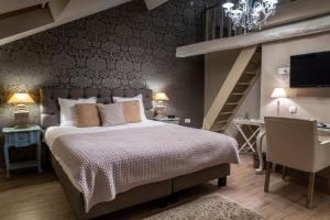 a bedroom with a large bed and a staircase at Boutique Hotel Caelus VII in Tongeren