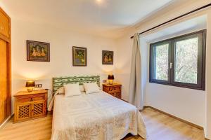um quarto com uma cama e uma janela em La Plana em Pollença