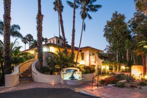 a house with a swimming pool and palm trees at Inn by the Harbor in Santa Barbara