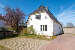 格拉爾－米里茨的住宿－Ferienwohnung BROMBEERE mit großem Garten und Balkon，白色的房子,有黑色的屋顶和砖砌车道