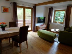 sala de estar con mesa y silla verde en Villa im Wald, en Rosshaupten