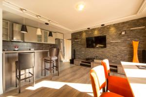 a kitchen with a bar and a tv on a brick wall at Ahoy Belgrade Luxury Apartment in Belgrade