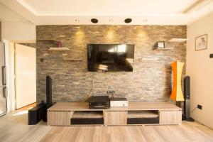 ein Wohnzimmer mit einem TV an einer Backsteinwand in der Unterkunft Ahoy Belgrade Luxury Apartment in Belgrad