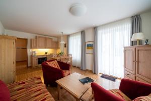 a living room with a table and chairs and a kitchen at Haus Sonnenschein Göhren in Göhren