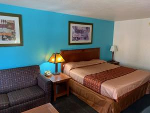 una stanza d'albergo con un letto e una sedia di Claridge Inn - St. George a St. George