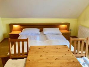 1 dormitorio con 2 camas y mesa de madera en Weingut - Ferienhaus Sonja Rohrbacher, en Gamlitz