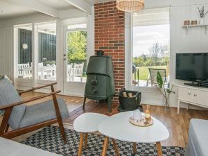 a living room with a couch and a tv at Three-Bedroom Holiday home in Ebeltoft 4 in Ebeltoft