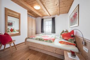 a bedroom with a bed and a chair at Pineiderhof in Funes