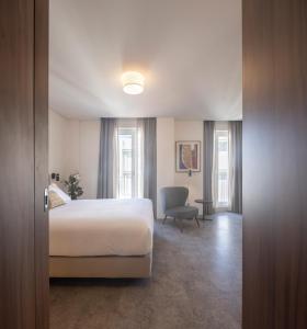a hotel room with a bed and a chair at Lisbon Serviced Apartments - Avenida in Lisbon