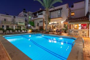 a swimming pool in a hotel at night at Galini Apartments in Hersonissos