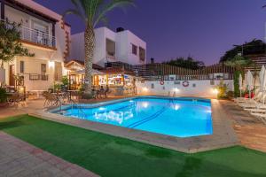 a swimming pool in front of a house at Galini Apartments in Hersonissos
