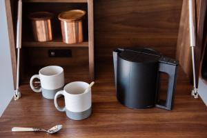 two coffee mugs and a trash can on a table at The Hoxton, Williamsburg in Brooklyn