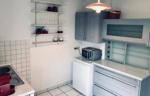 a kitchen with blue cabinets and a microwave at Ferienzimmer in Allensbach in Allensbach