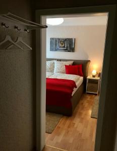 Ferienzimmer in Allensbach في ألينسباخ: غرفة نوم بسرير ومخدات حمراء
