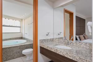 a bathroom with a sink, toilet and bathtub at Wyndham Olímpia Royal Hotels in Olímpia